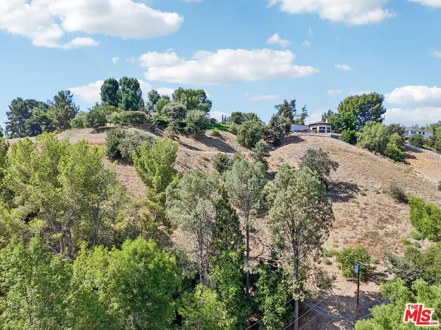 a view of a pathway both side of grassy field with shrub