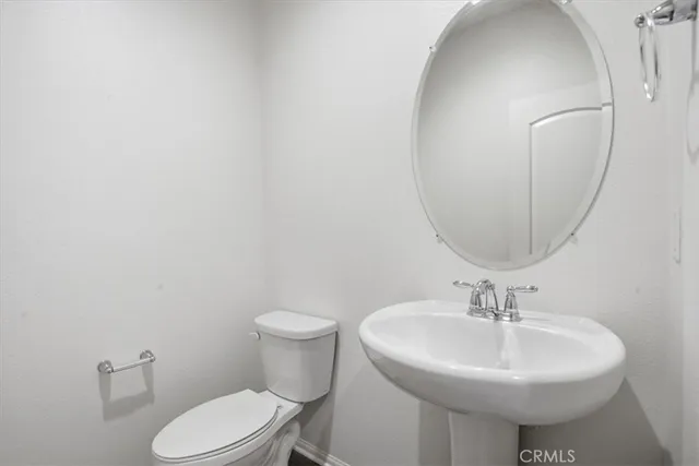 a bathroom with a sink a toilet and mirror