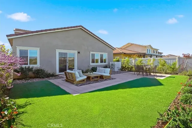 a view of a house with a backyard and sitting area
