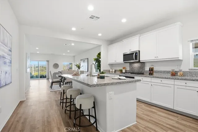 a kitchen with sink cabinets stainless steel appliances and dining table