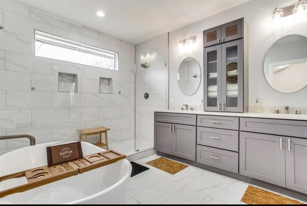 1606 West 12th Street Dallas, TX 75208 - Photo 10 of 20 Bathroom with double vanity, a freestanding bath, a shower stall, and light marble finish floors