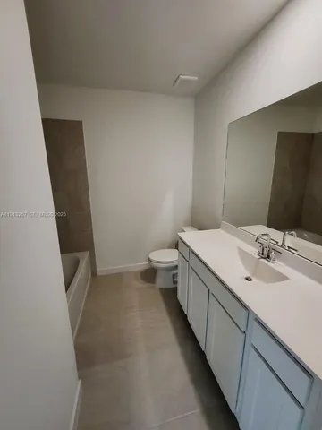 a bathroom with a sink and mirror with toilet