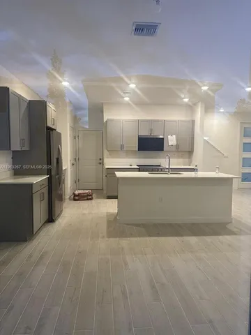 a large kitchen with stainless steel appliances lots of counter top space cabinets and a sink