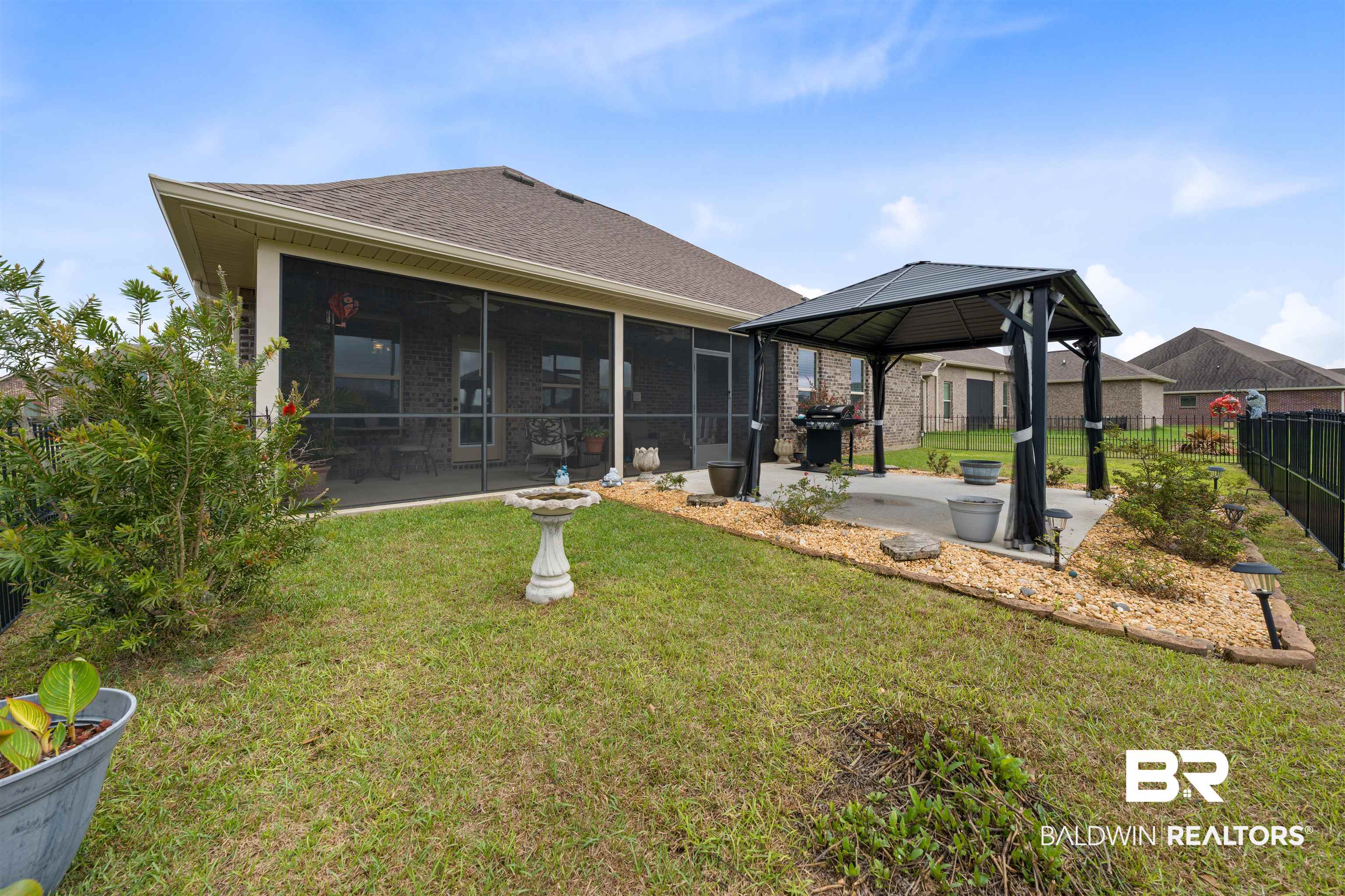 22512 Putter Lane Foley, AL 36535 - Photo 20 of 27 Back of house with a fenced backyard, a patio area, a sunroom, and roof with shingles