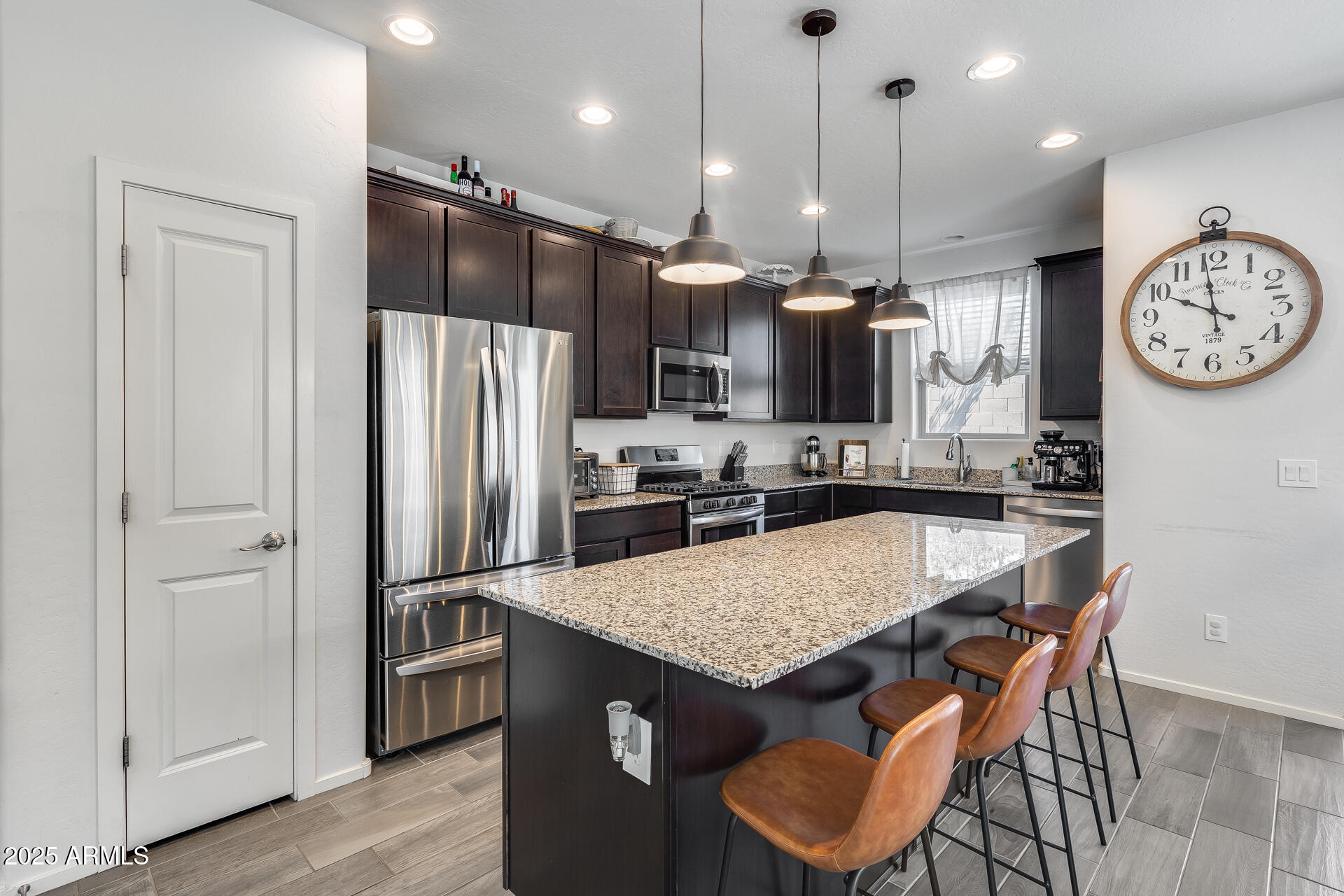 14344 West Hackamore Drive Surprise, AZ 85387 - Photo 25 of 41 a kitchen with granite countertop a table chairs stainless steel appliances and cabinets