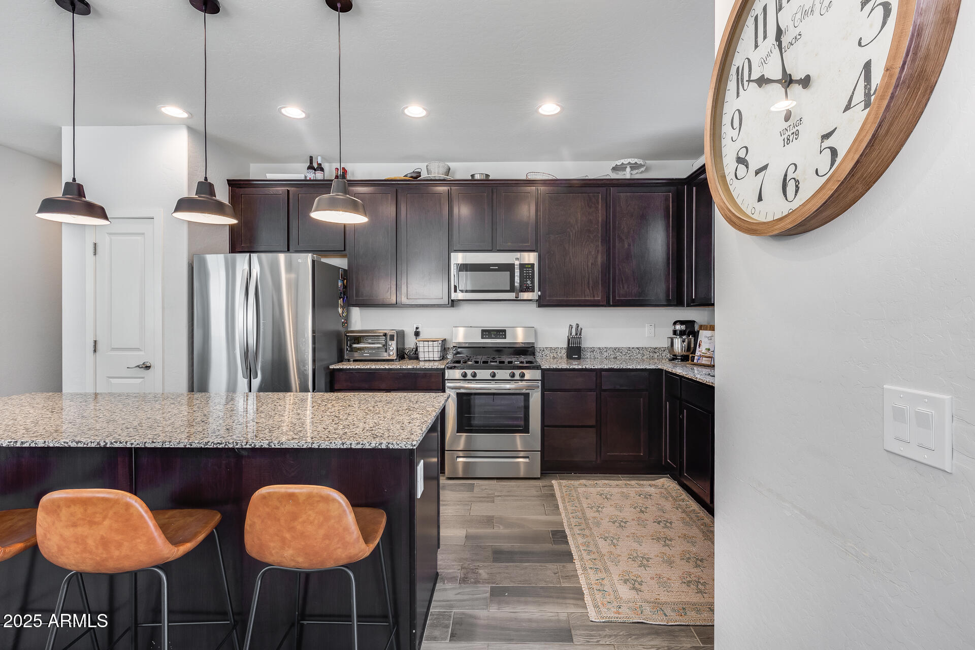 14344 West Hackamore Drive Surprise, AZ 85387 - Photo 29 of 41 a kitchen with stainless steel appliances granite countertop a stove a refrigerator a sink a oven with a dining table and chairs
