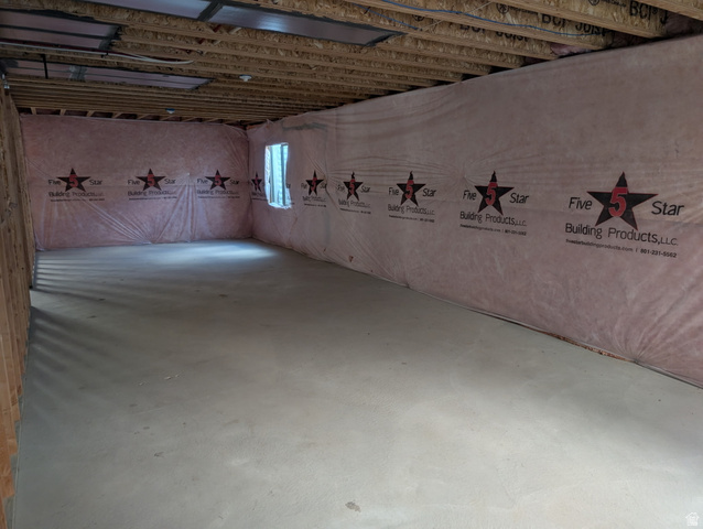 3831 South Powderwood Lane, Unit 111 Mapleton, UT 84664 - Photo 11 of 12 Unfinished basement space featuring a concrete floor, exposed wood ceiling joists, and insulated perimeter walls