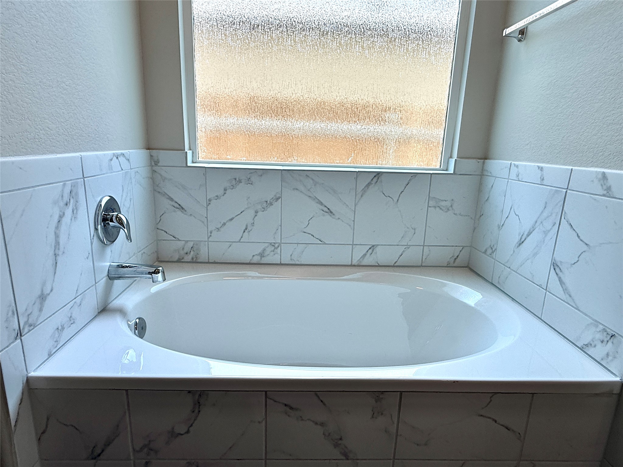 129 Perfect World Loop Jarrell, TX 76537 - Photo 17 of 31 Indulge in a tranquil soak within this well-appointed bathtub, framed by elegant tile work.