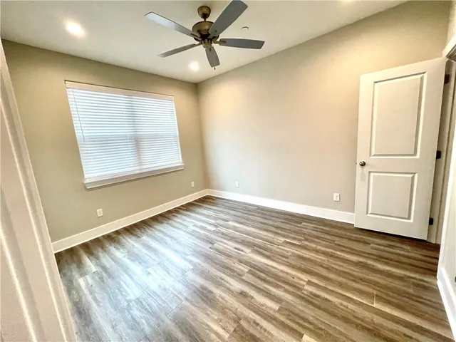 an empty room with windows and fan