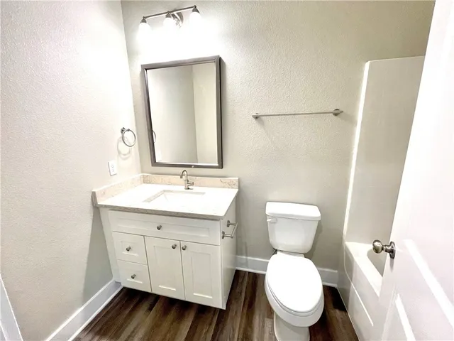 a bathroom with a bathtub sink mirror vanity and toilet
