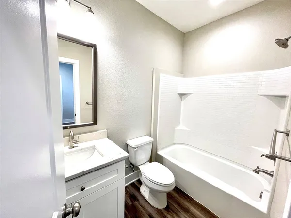 a bathroom with a sink a toilet a mirror and shower