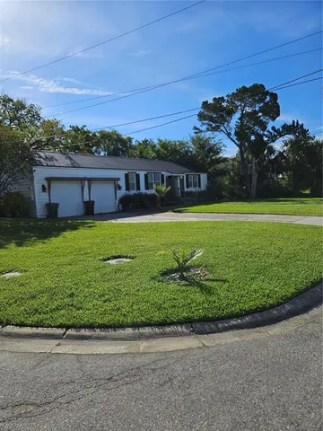 a front view of a house with a garden and trees