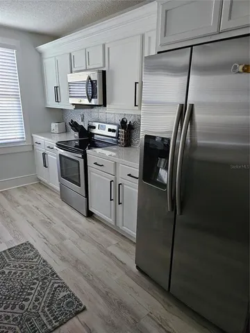 a kitchen with stainless steel appliances and a refrigerator