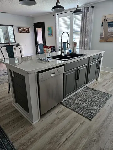 a kitchen with sink and view of living room