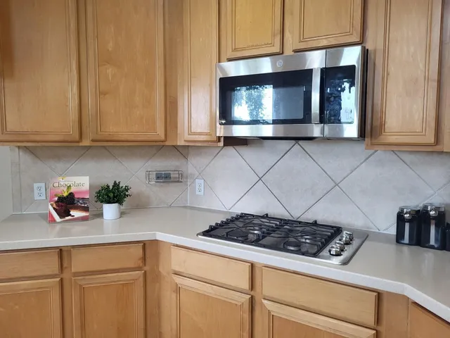 a kitchen with microwave cabinets and a stove top oven