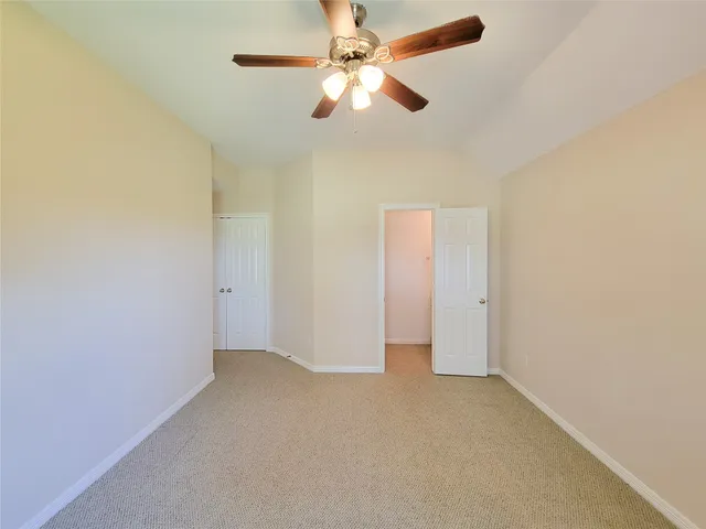 an empty room with closet and a chandelier fan