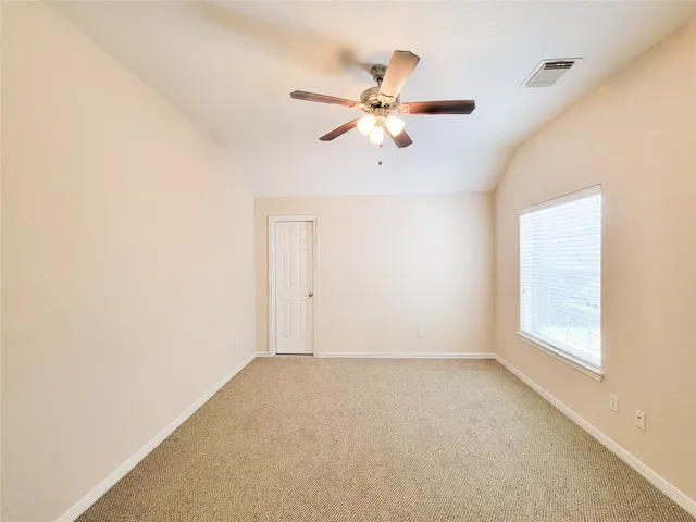 an empty room with a window and a fan