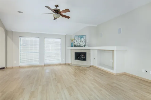 a view of empty room with a fireplace and fan