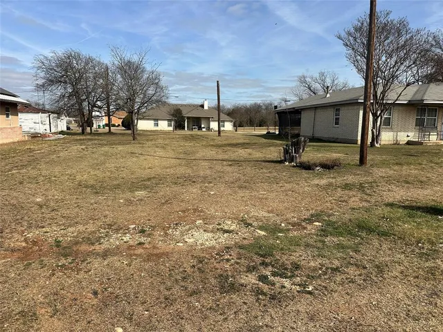 a view of a backyard with large trees