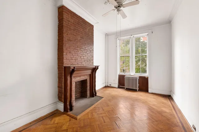 a view of an empty room with a fireplace and a window