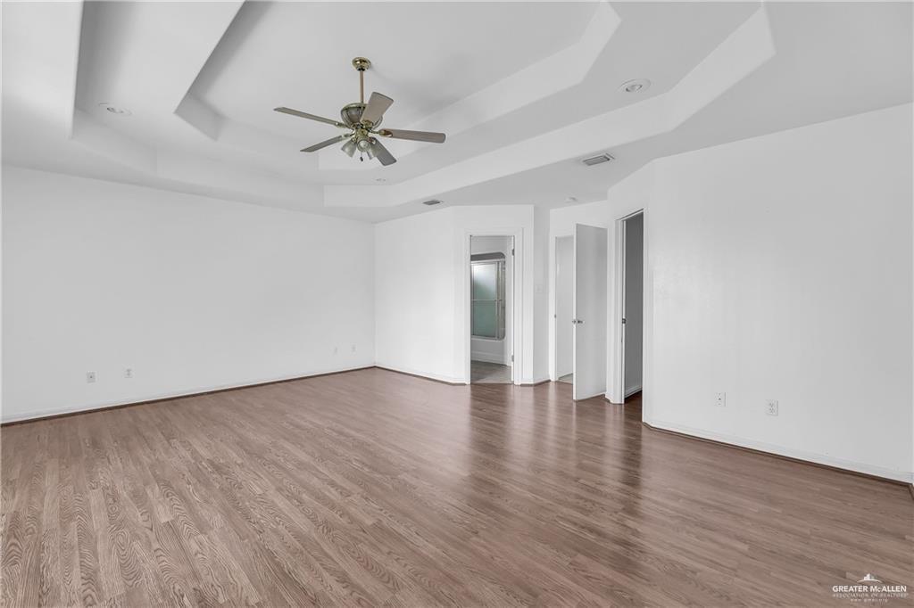 2002 Meadow Way Drive Mission, TX 78572 - Photo 11 of 20 an empty room with wooden floor ceiling fan and windows
