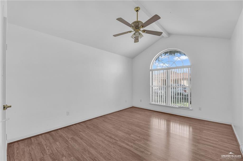 2002 Meadow Way Drive Mission, TX 78572 - Photo 14 of 20 an empty room with wooden floor chandelier fan and windows