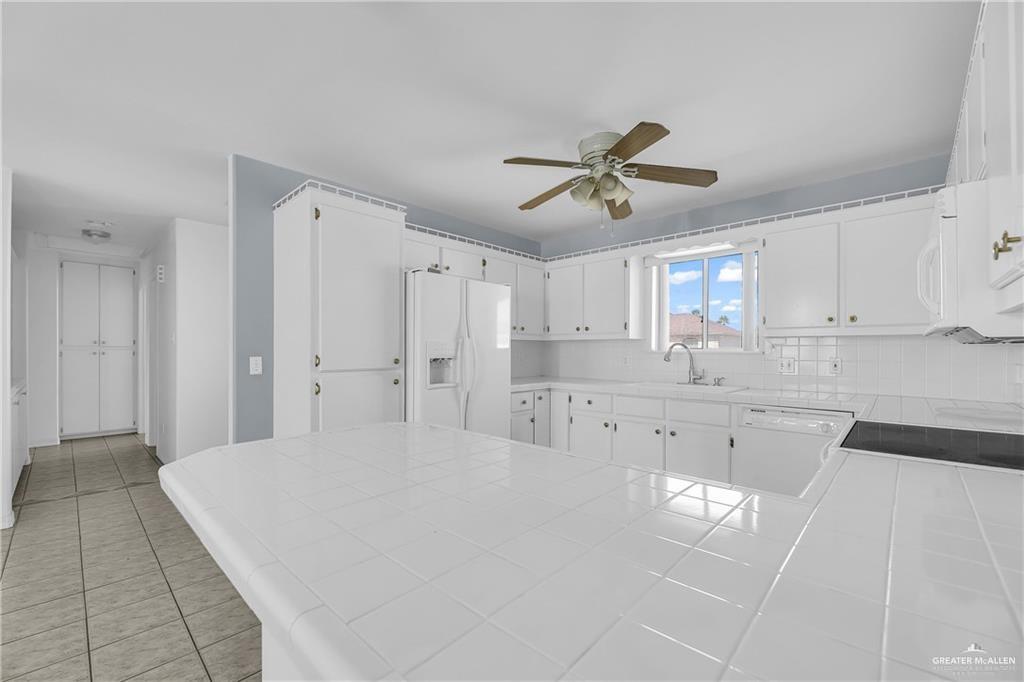 2002 Meadow Way Drive Mission, TX 78572 - Photo 8 of 20 a large white kitchen with kitchen island white cabinets and stainless steel appliances