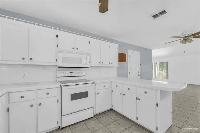 a kitchen with white cabinets and white appliances