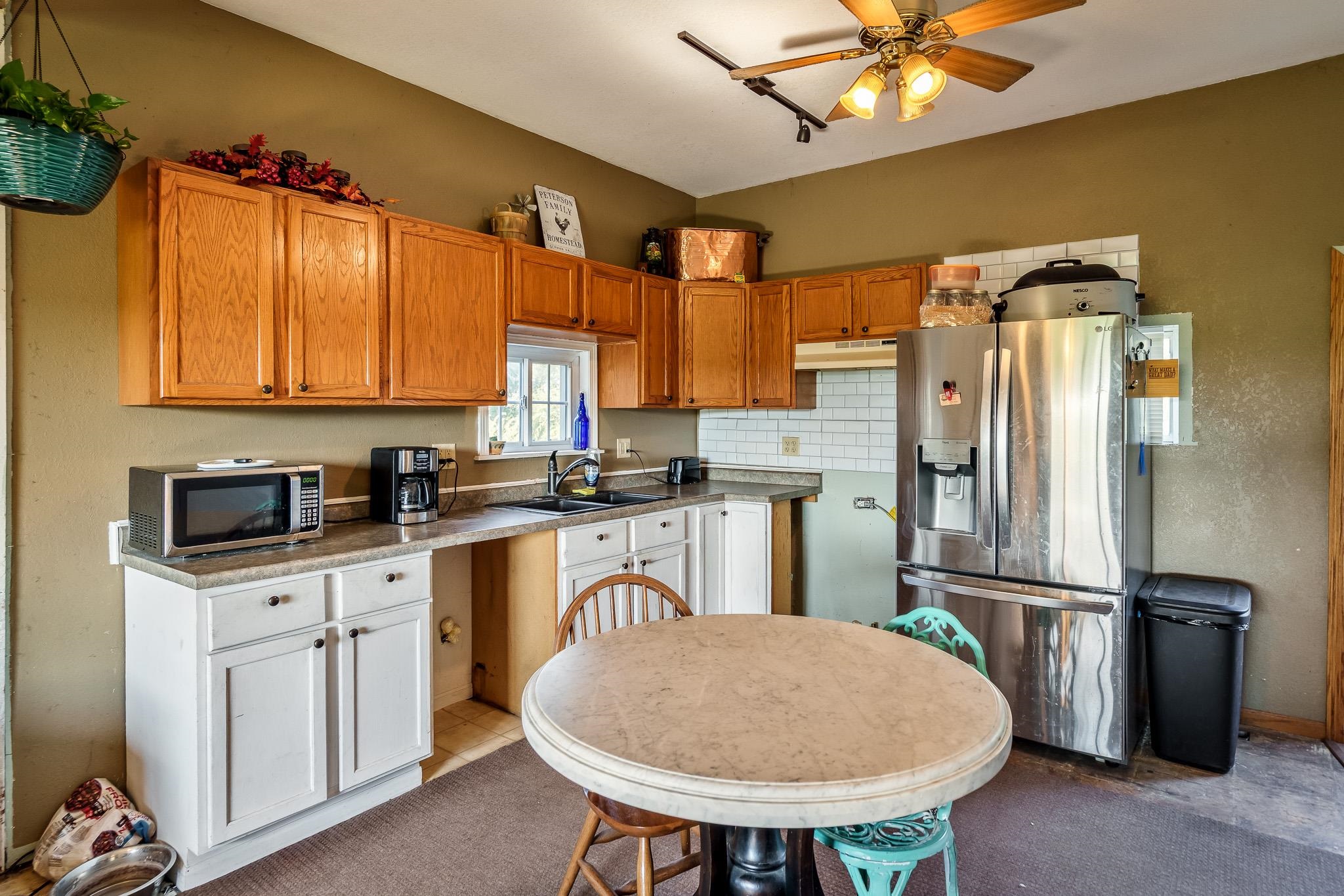 6913 West Wagner Road German Valley, IL 61039 - Photo 42 of 54 a kitchen with stainless steel appliances a refrigerator a sink a stove white cabinets and blue chairs