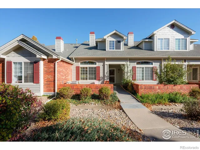 a front view of a house with a yard and potted plants