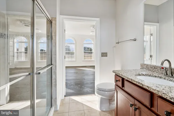 a view of an empty room with wooden floor and a chandelier