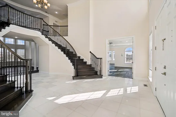 an empty room with wooden floor chandelier and windows