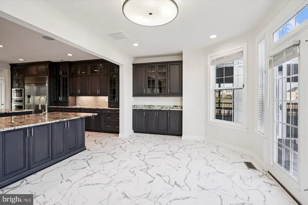 an empty room with wooden floor fireplace and windows