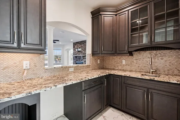 a kitchen with kitchen island granite countertop wooden cabinets and a counter top space