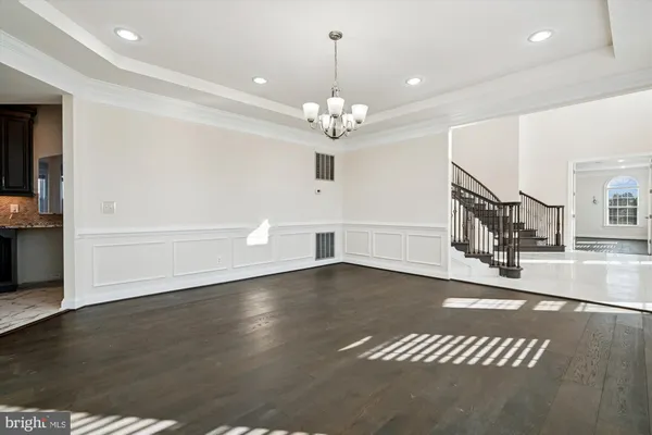 a view of an empty room with wooden floor and windows