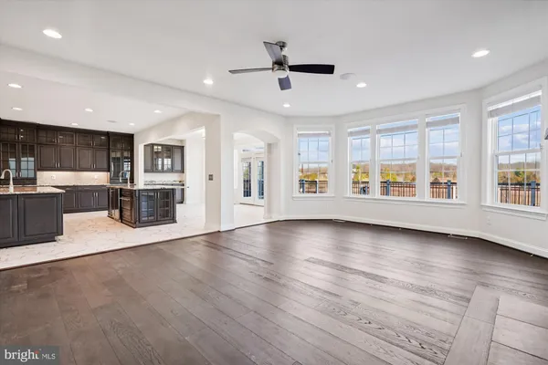 a view of a livingroom with wooden floor and a ceiling fan