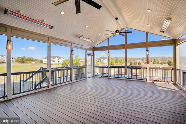an empty room with floor to ceiling windows and wooden floor