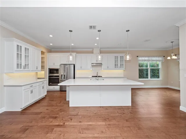 a kitchen with stainless steel appliances a sink and a white cabinets