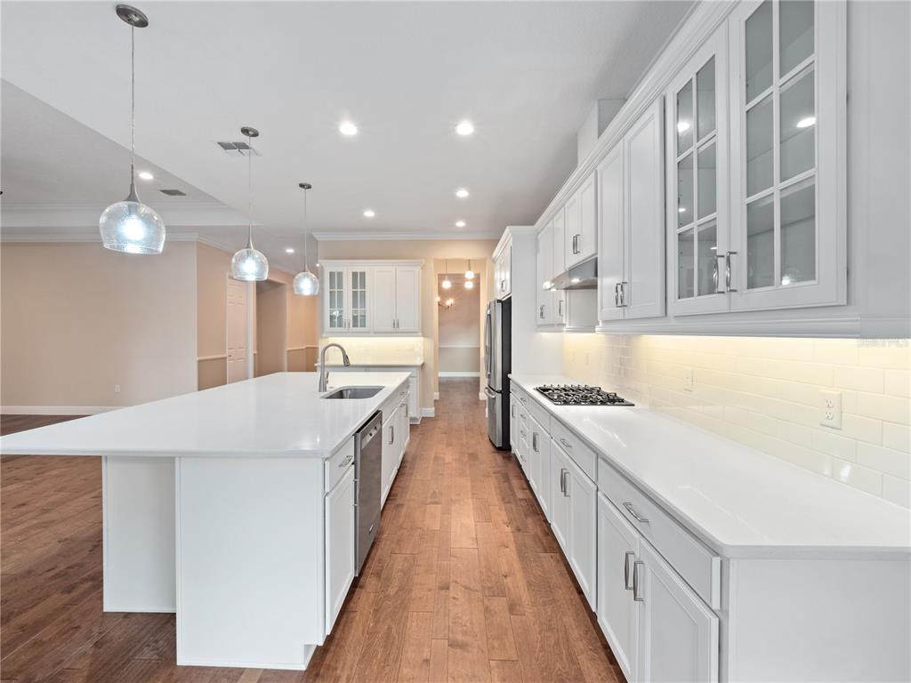 2922 Reef Knot Place Winter Park, FL 32792 - Photo 14 of 49 a large kitchen with stainless steel appliances kitchen island a large counter top a stove and a chandelier