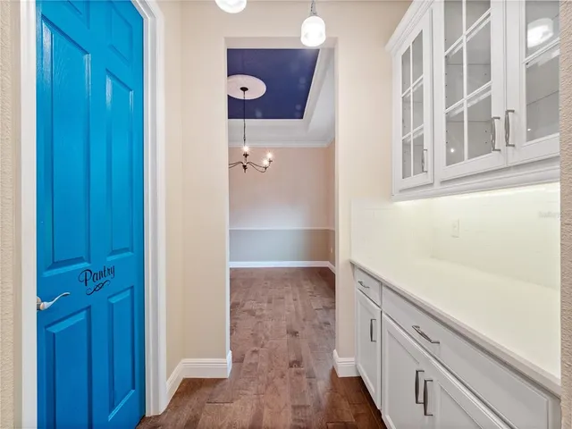 an empty room with wooden floor and a ceiling fan