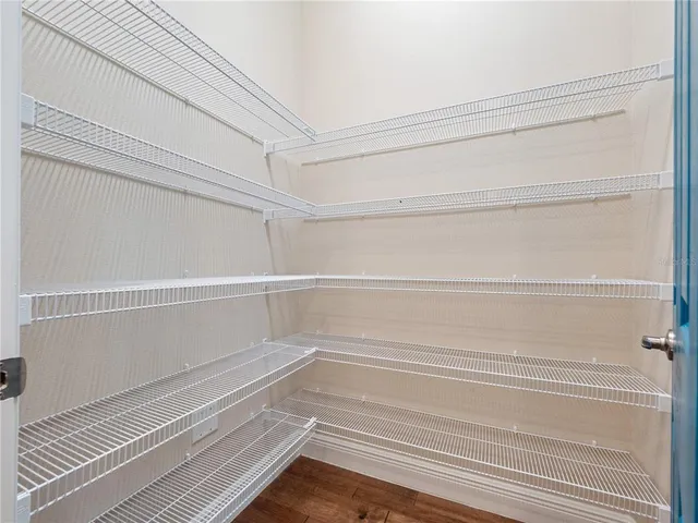 a view of an empty room with windows and chandelier