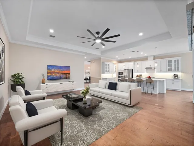 a living room with furniture kitchen view and a chandelier