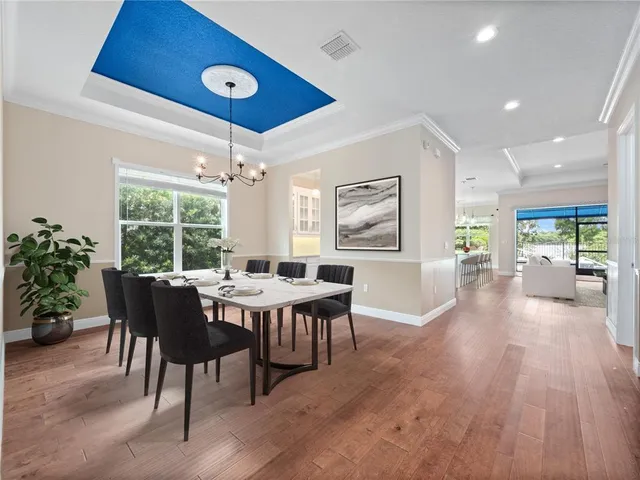 a large kitchen with kitchen island a sink white cabinets and wooden floor