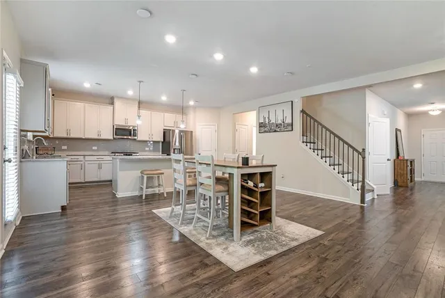 a kitchen with stainless steel appliances kitchen island granite countertop a stove a sink a refrigerator and cabinets