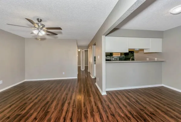 a view of a kitchen with wooden floor and a ceiling fan