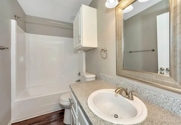 a bathroom with a sink a toilet and shower