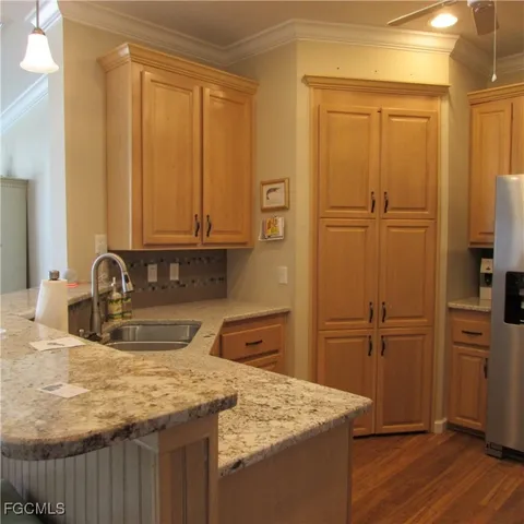 a kitchen with stainless steel appliances granite countertop a sink refrigerator and cabinets