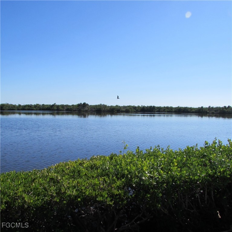 5371 Blue Crab Circle, Unit 1 Bokeelia, FL 33922 - Photo 24 of 44 a view of a lake with houses in the back