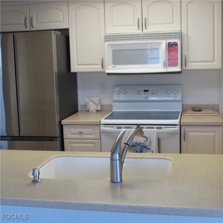 5371 Blue Crab Circle, Unit 1 Bokeelia, FL 33922 - Photo 37 of 44 a kitchen with appliances and cabinets
