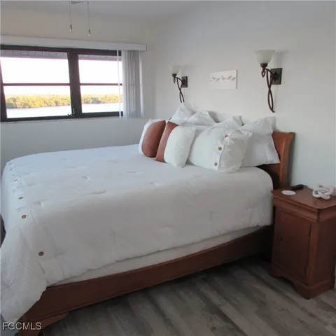 a bedroom with a bed and a large window